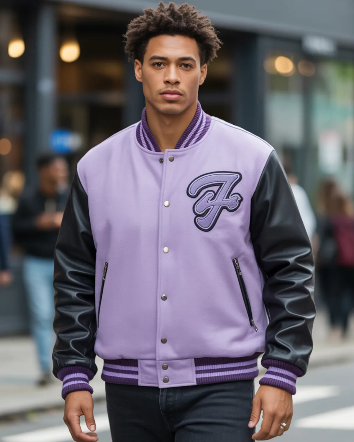 Person wearing a purple varsity jacket with black sleeves in an urban setting
