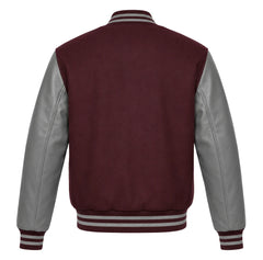 A classic varsity jacket shown from the back, featuring a deep maroon wool body and contrasting light grey leather sleeves, with striped ribbed collar, cuffs, and hem.