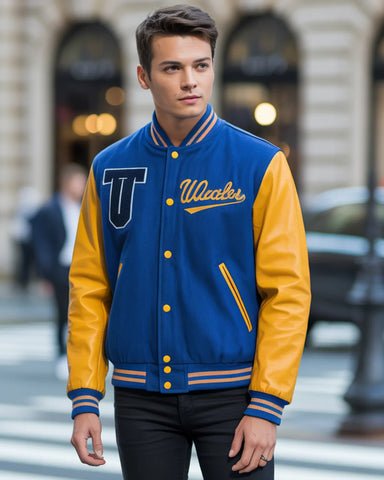 Man wearing a blue and yellow varsity jacket with 'UWales' on a city street.